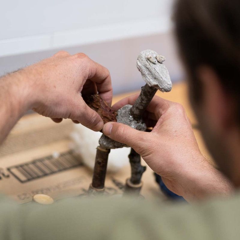 Ein Mann erstellt eine Figur aus Stein und Holz
